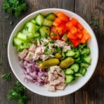 Tuna salad with vegetables on white plate