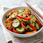 Asian cucumber salad in white bowl with sesame seeds