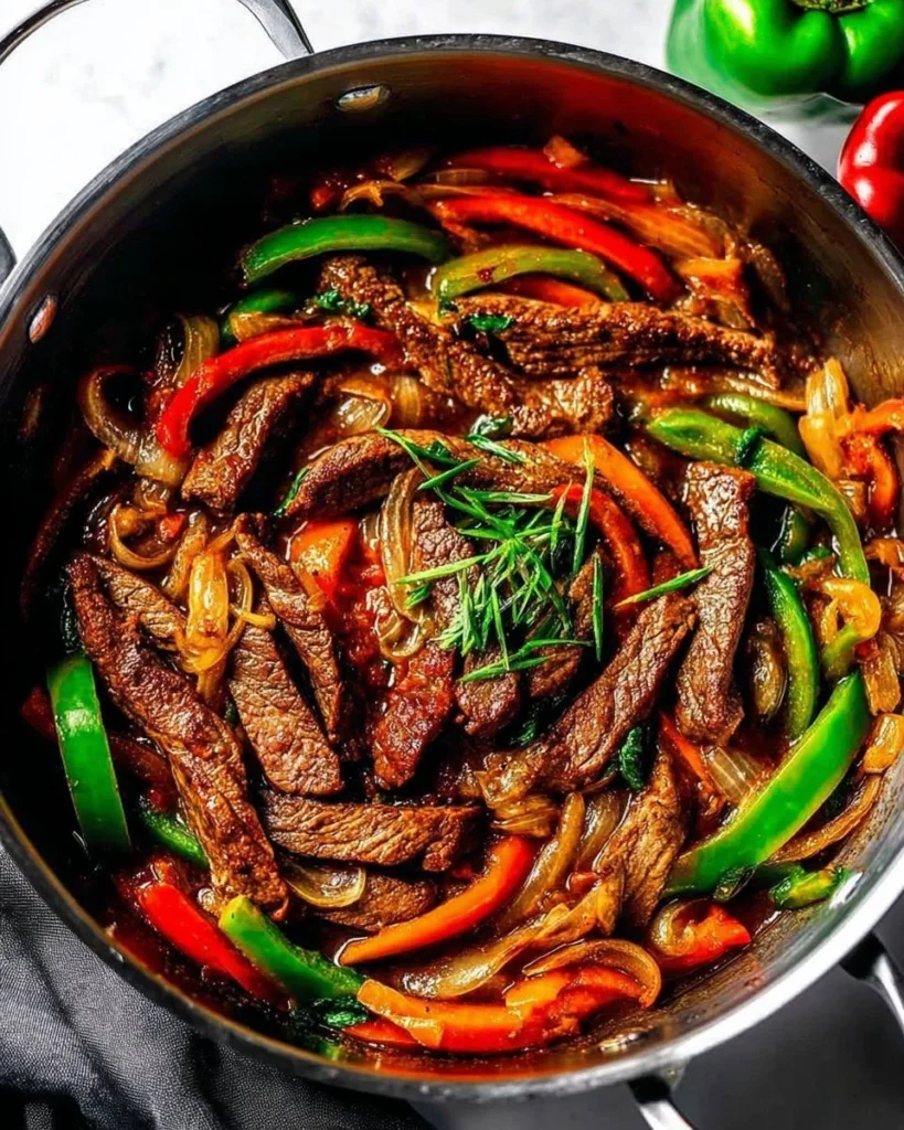 Delicious pepper steak served with vegetables and rice on a white plate