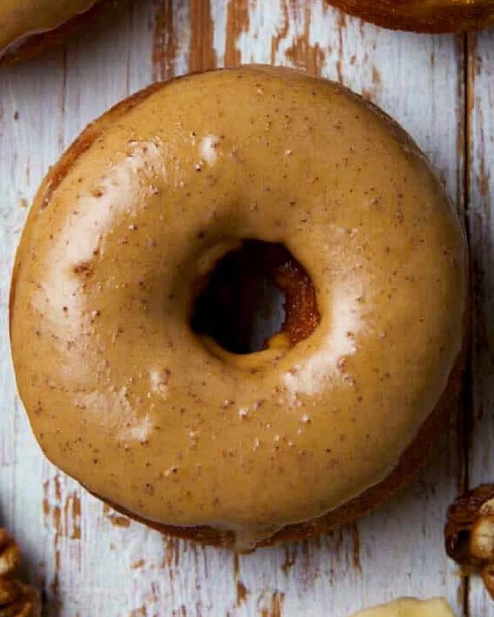 Homemade banana donuts ready to be served, topped with icing and sprinkles.