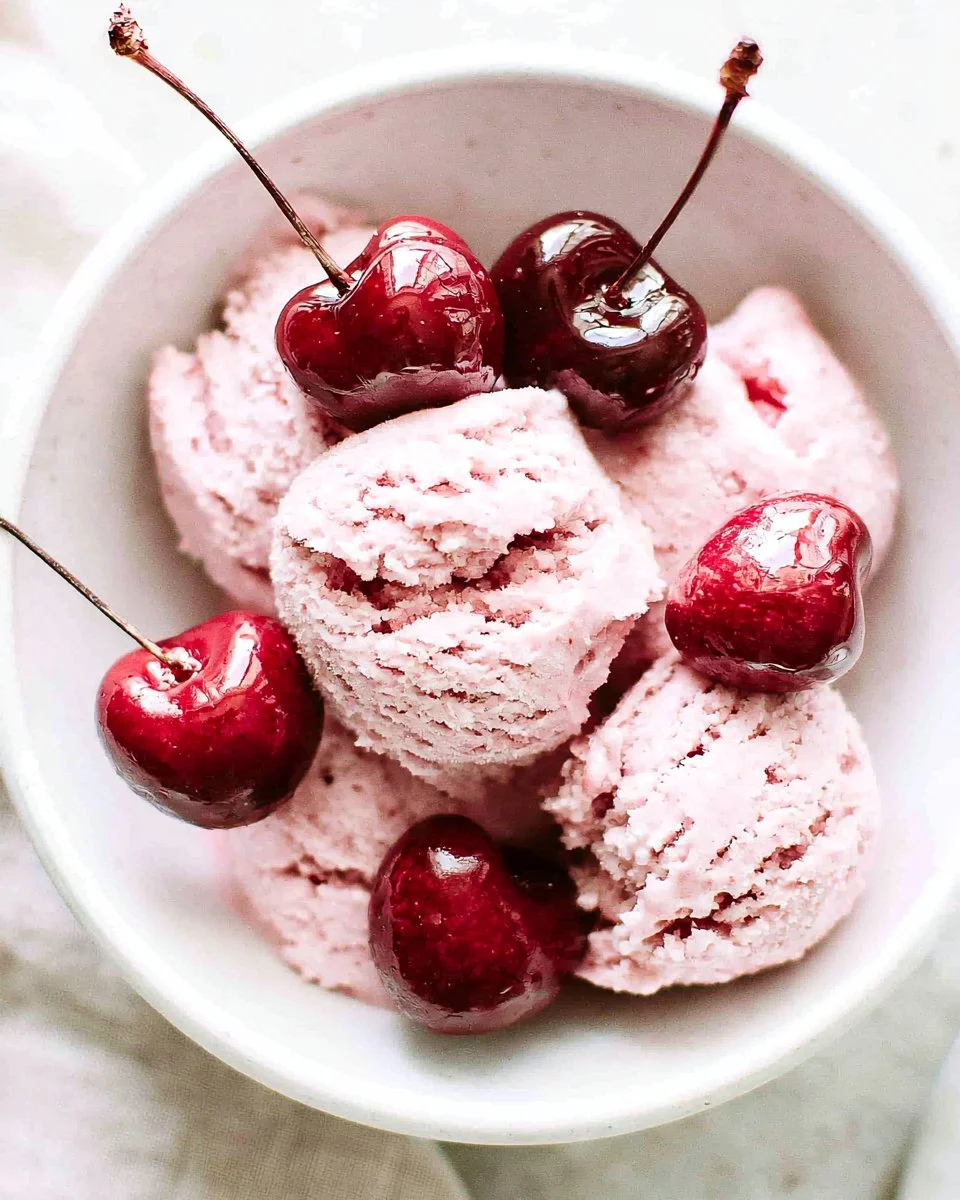 Delicious bowl of cherry ice cream topped with fresh cherries