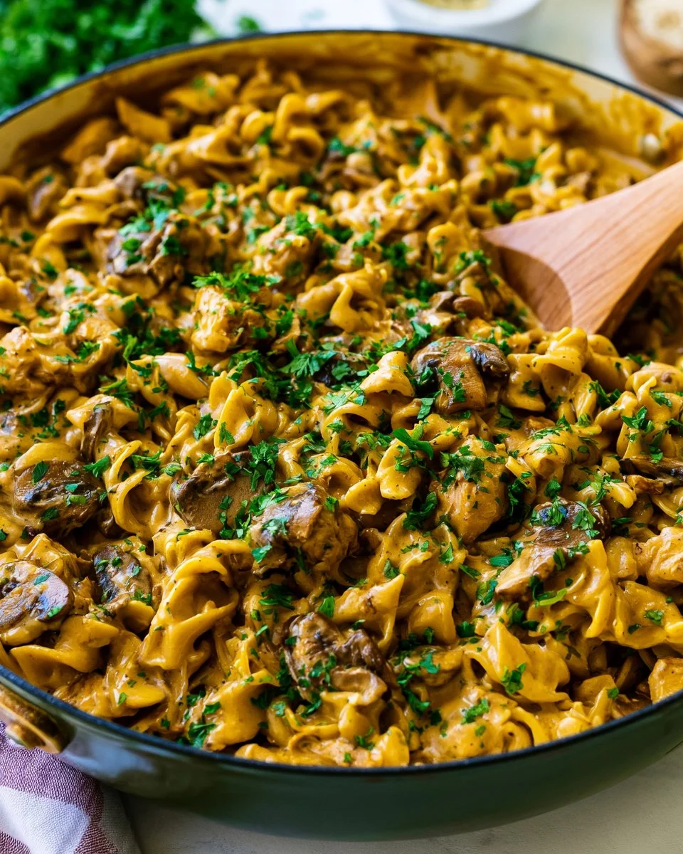 Delicious Chicken Stroganoff served over noodles with herbs and creamy sauce