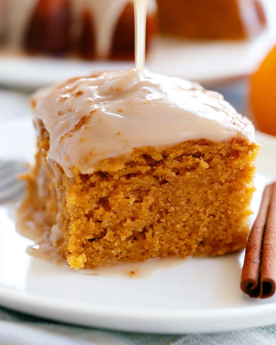 Delicious pumpkin spice cake with apple cider glaze on a rustic wood table